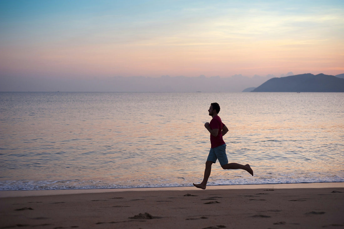 Man running along beach sunrise